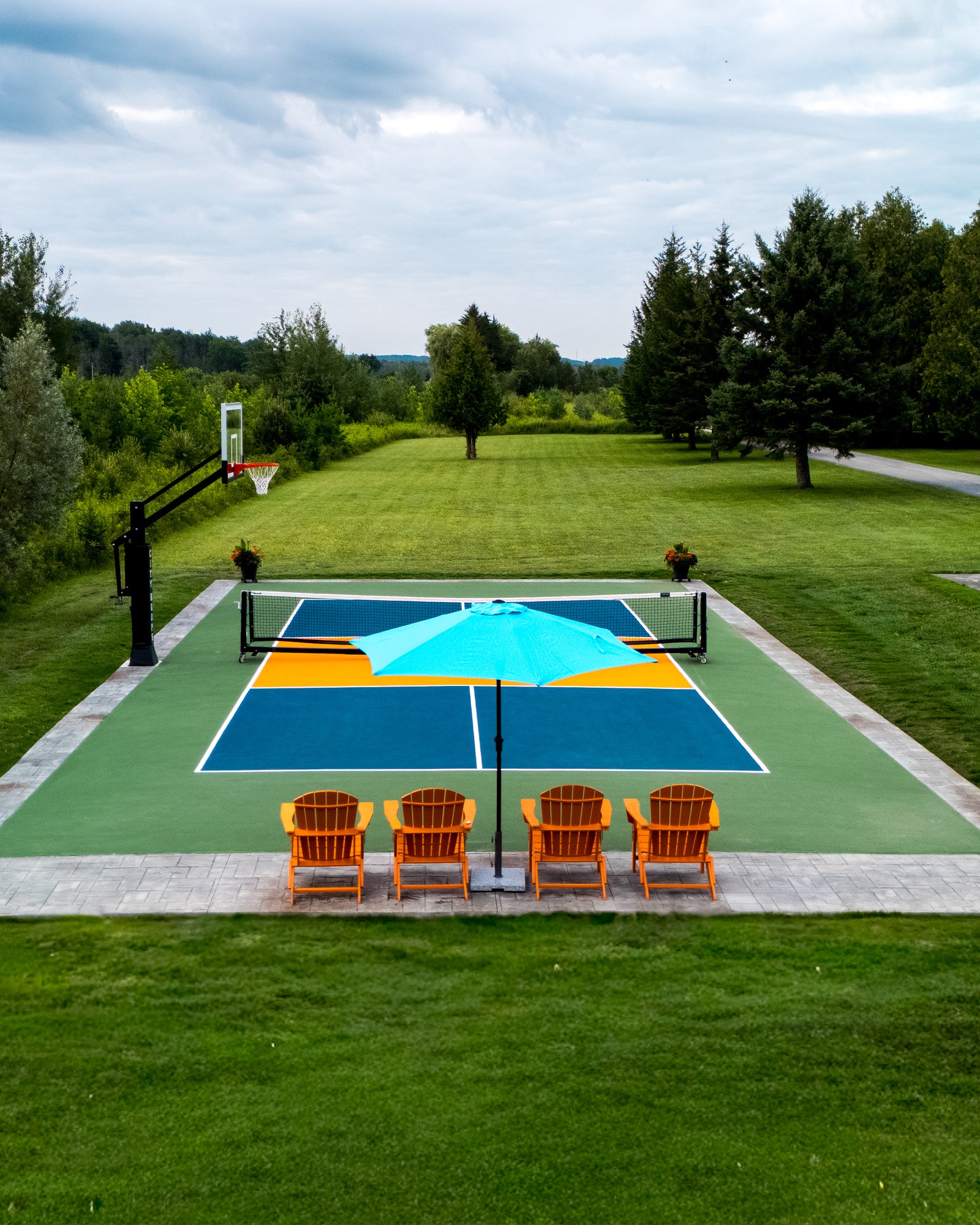 outdoor backyard pickleball court with cloud cushion system and a city hoops basketball system