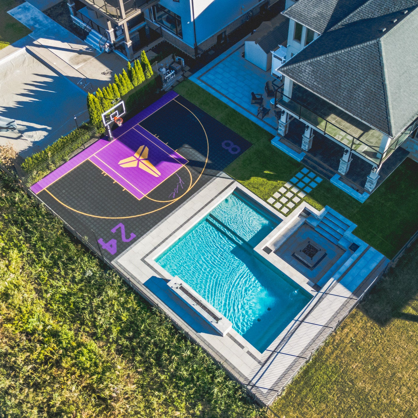 Aerial view of a backyard with a basketball court and pool.